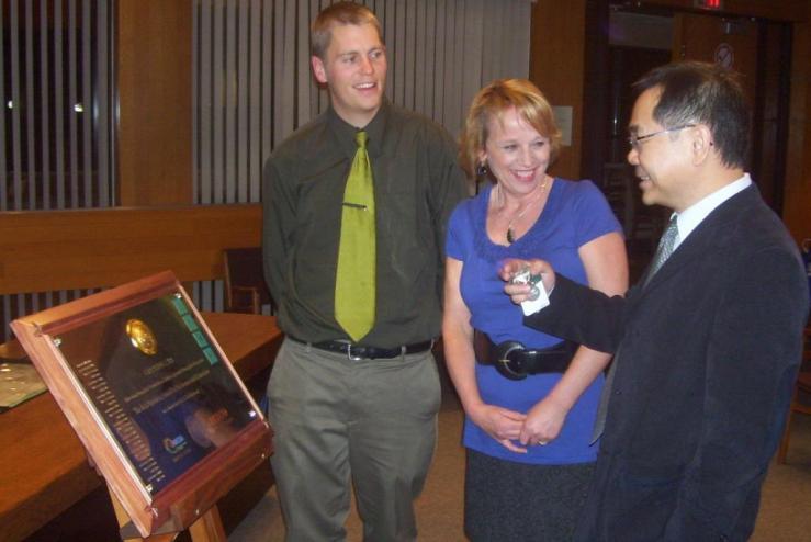 Michael Wolfe, Carol Day, and Chak Au with an award plaque from IESCO.
